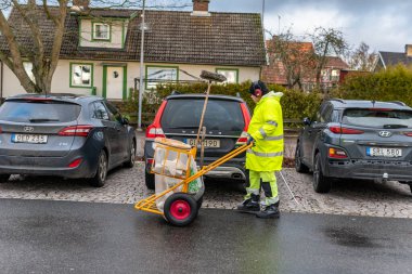 İsveç, Knislinge 3 Ocak 2023: üniformalı bir adam çöp topluyor, sokakları temizliyor. Çöpçü, çöpçü, çöpçü, Ashman.. 