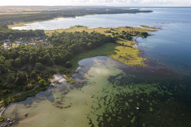 Güzel bir deniz manzarası, vahşi doğa, bir sürü taş, ağaç ve çimen. Vahşi doğası olan küçük bir ada. Vahşi sahil, çayır. 