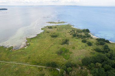 Güzel bir deniz manzarası, vahşi doğa, bir sürü taş, ağaç ve çimen. Vahşi doğası olan küçük bir ada. Vahşi sahil, çayır. 