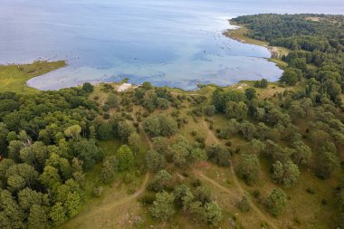 Güzel bir deniz manzarası, vahşi doğa, bir sürü taş, ağaç ve çimen. Vahşi doğası olan küçük bir ada. Vahşi sahil, çayır. 