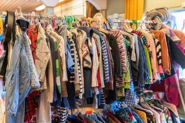 İsveç, Malmö 8 Temmuz 2023: Askılarda farklı giysiler, ikinci el mağazasında asılı kıyafetler