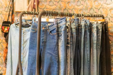 İsveç, Malmö 8 Temmuz 2023: Askılarda farklı giysiler, ikinci el mağazasında asılı kıyafetler