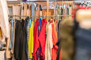 İsveç, Malmö 8 Temmuz 2023: Askılarda farklı giysiler, ikinci el mağazasında asılı kıyafetler