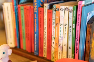 İsveç, Malmö 8 Temmuz 2023: Bir kütüphane rafında veya ikinci el dükkanında İsveççe çocuk kitapları