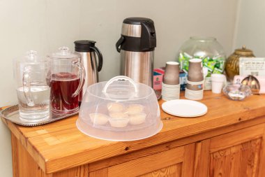 Tatlılı servis masası: bisküvi, çay ya da kahve ile termoslar, su ya da meyve suyu ile sürahiler. Tek kullanımlık bardaklar.