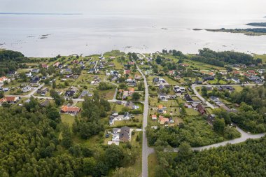 Deniz kenarındaki küçük köyün havadan görünüşü, deniz kenarındaki birçok özel ev, sahil köyü, tatil köyü.