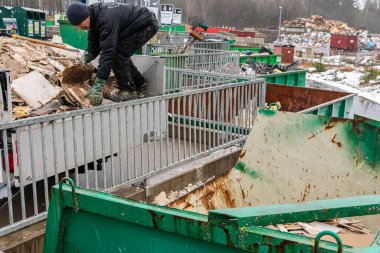 İsveç, Malmö 13 Mart 2023: Çöp toplama istasyonundaki enkazı sıralayan bir adam. Çöp ve atık dolu bir sürü büyük konteynır..