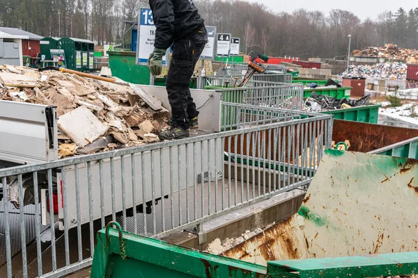 İsveç, Malmö 13 Mart 2023: Çöp toplama istasyonundaki enkazı sıralayan bir adam. Çöp ve atık dolu bir sürü büyük konteynır..