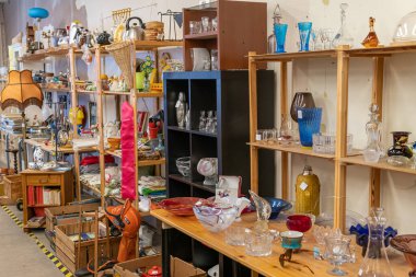 İsveç, Malmö 1 Nisan 2023: Bir ikinci el mağazasında bir sürü farklı ev ve eski eşya. İskandinav ülkelerindeki tipik kullanılmış eşyalar ve nadir bulunan şeyler dükkânı. Bit pazarı. 