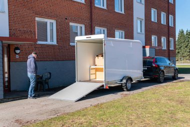 İsveç, Malmö 2 Nisan 2023: Erkekler eşyaları büyük bir karavana yüklüyor. Farklı eşyalarla dolu bir minibüsü paketlemek, taşınmak....