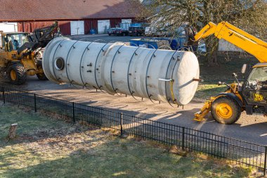İsveç, Malmö 3 Nisan 2023: Telgraf idarecisi ve ön-uçtaki yükleyiciyle büyük bir sanayi bölgesinin taşınması 