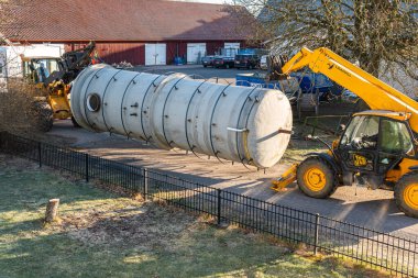 İsveç, Malmö 3 Nisan 2023: Telgraf idarecisi ve ön-uçtaki yükleyiciyle büyük bir sanayi bölgesinin taşınması 