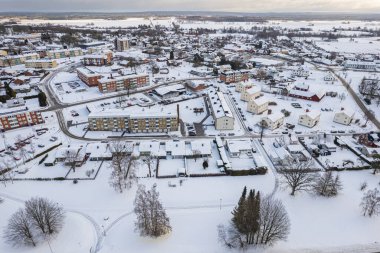 İsveç 'te kışın alçak katlı ve özel binaları olan yerleşim alanının havadan görüntüsü. Karlı hava, küçük bir Avrupa köyünde kar yağışı, kasaba, şehir.