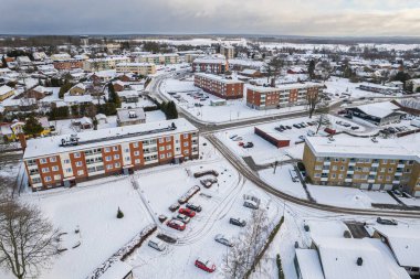 İsveç 'te kışın alçak katlı ve özel binaları olan yerleşim alanının havadan görüntüsü. Karlı hava, küçük bir Avrupa köyünde kar yağışı, kasaba, şehir.