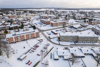 İsveç 'te kışın alçak katlı ve özel binaları olan yerleşim alanının havadan görüntüsü. Karlı hava, küçük bir Avrupa köyünde kar yağışı, kasaba, şehir.
