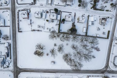 İsveç 'te kışın alçak katlı ve özel binaları olan yerleşim alanının havadan görüntüsü. Karlı hava, küçük bir Avrupa köyünde kar yağışı, kasaba, şehir.