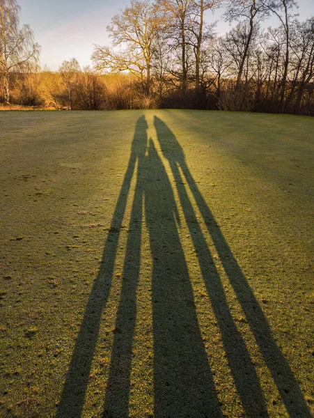 Long shadow of a family outdoors on a sunny day