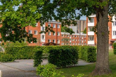 Typical low-rise residential buildings in Sweden. Comfortable recreational area during a hot summer day.  clipart