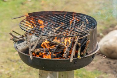 Izgarada kızgın bir ateş, kurumuş dallar yanıyor.