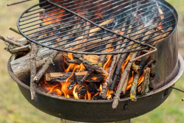 Izgarada kızgın bir ateş, kurumuş dallar yanıyor.