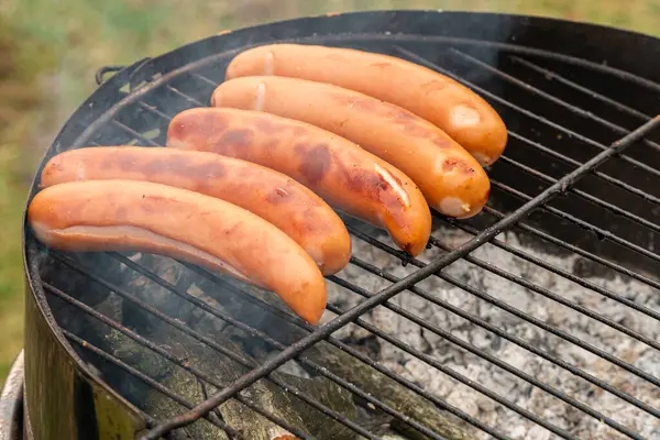 stock image Sausages grilling on an outdoor barbecue