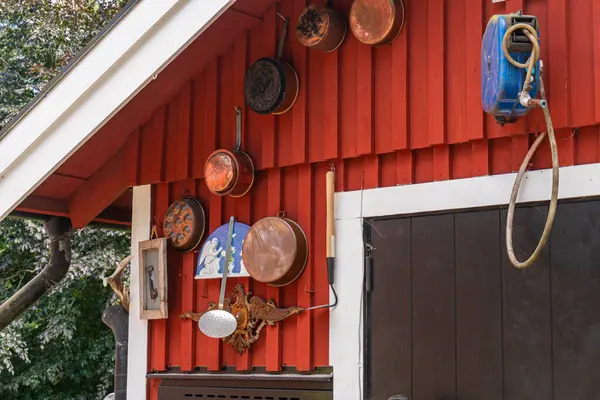 stock image Sweden, Tocken  July 22, 2023: Many old vintage items hanging on the house. Various decorations and ornaments. Garage sale, flea market, second-hand.