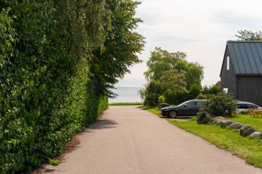 Denize giden bir yol güzel ve varlıklı özel evlerin yanından geçiyor.