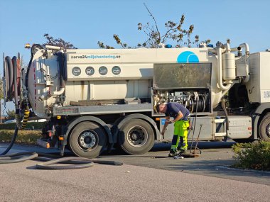 İsveç, Malmö 19 Eylül 2024: Profesyonel bir işçi özel bir iş kamyonunun önünde kanalizasyon temizliyor