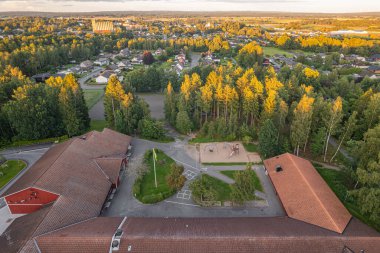 A modern school in a small European village. Drone view, concept. clipart