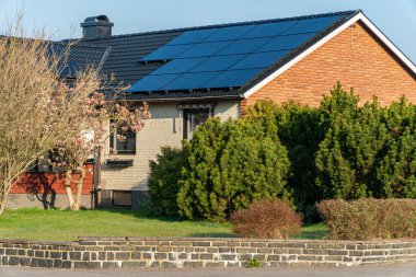 Özel bir evin çatısına güneş panelleri monte edilmiş. Yeşil enerji ve modern teknoloji.