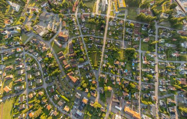 Küçük bir İsveç kasabasının geniş açılı hava manzarası. Konut ve özel evleri, sokakları, yeşillikleri ve insansız hava aracı tarafından ele geçirilmiş şehir altyapısı.