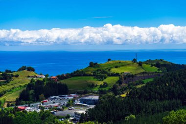 Yeşil tepelere ve Atlantik Okyanusuna bakan manzara