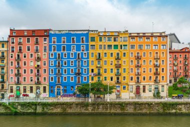 Bilbao, İspanya - 08.06.2022: Nervion Nehri 'nin çok renkli evleri. Renkli mimari, Bilbao, İspanya