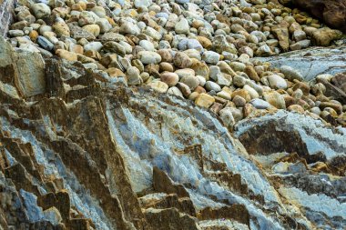 Deniz kıyısındaki çakıl taşları ve kayalar. Kayalık okyanus kıyısı