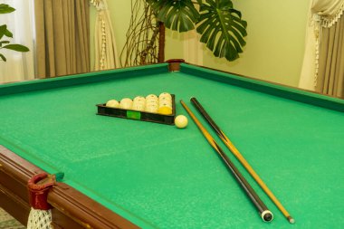 Üçgen şeklinde bilardo topları ve masada bir ıstaka.
