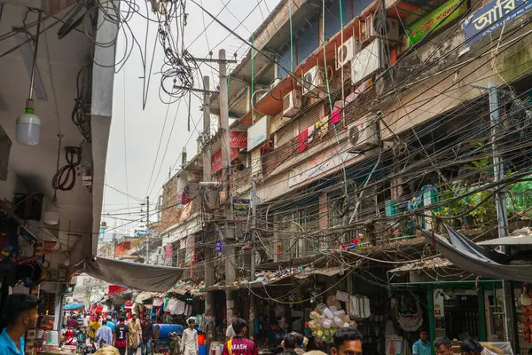 stock image Bangladesh, Rajshahi - 04.21.2023: Tangled cables and messy electricity system hang in huge bunches above many of crowded streets