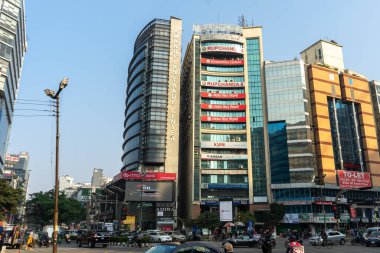 Dhaka, Bangladeş - 05.16.2023: Dhaka 'daki modern ofis binaları gündüz yoğun sokak trafiği olan Amanullah Ticaret Merkezi. Reklamları ve canlı kentsel atmosferi olan yüksek binalar