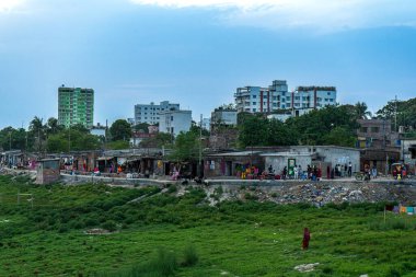 Değişen yükseklikleri olan şehir manzarası, ön planda yeşil alan ve insanlar, Rajshahi Bangladeş seti.