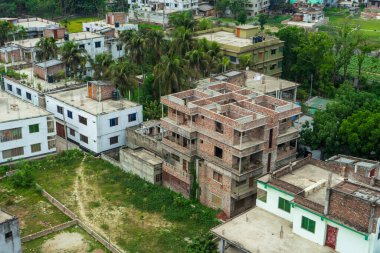 Yeşillik, Rajshahi ve Bangladeş 'teki yerleşim alanlarının ortasındaki inşaat altındaki bir binanın havadan görüntüsü.