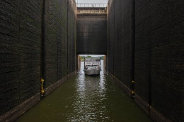 14 Jan. 2023. Barra Bonita - Brazil: Tour boat with tourists sailing towards the Barra Bonita lock, used to bridge the gaps between the upper and lower levels of the dam.