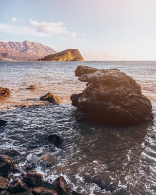 Kaya ve dağlarla kaplı güzel bir deniz manzarası.