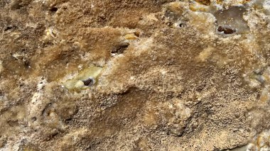 Kabataslak desenli ve çeşitli kahverengi ve bej tonlu doğal soyut taş arka plan. Toprak tonları ve mineral oluşumları olan desenli kaya yüzeyine yakın çekim