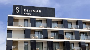 La Pobla de Farnals, Valencia, İspanya - 04 Mayıs 2025: Estimar Hotels binasının dış görünüşü, açık mavi gökyüzüne karşı birden fazla balkon ile modern mimari tasarımını sergiliyor 