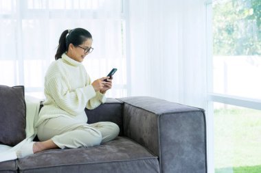 Kadınlar kanepede oturarak vakit geçirirler. 