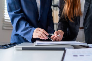 İş kadını iş yerinde ya da evde koltukta oturup dizüstü bilgisayar üzerinde çalışıyor ve şirket için iş planı ve stratejiler oluşturmak için çizelgeler ve grafikler üzerindeki verileri analiz ediyor ve kağıtlara yazıyor. İş konsepti.