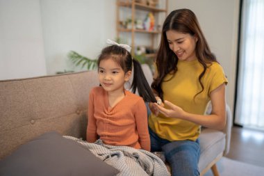 Sevgili anne ve küçük kız oturma odalarında birlikte vakit geçiriyorlar..