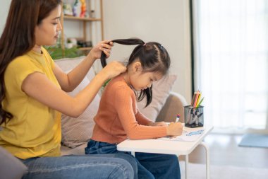 Sevgili anne ve küçük kız oturma odalarında birlikte vakit geçiriyorlar..