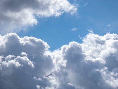 Güneşli bir günde kabarık beyaz bulutlu mavi gökyüzü manzarası. Karanlık gökyüzünün arka planı güzel beyaz bulutlarla aydınlandı.