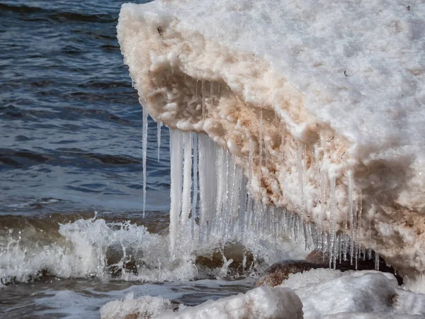 明るい日差しの中で海岸沿いのバルト海の水の中で雪 氷とつららの形成のクローズアップショット 冬の氷結した氷塊と海水 — ストック写真