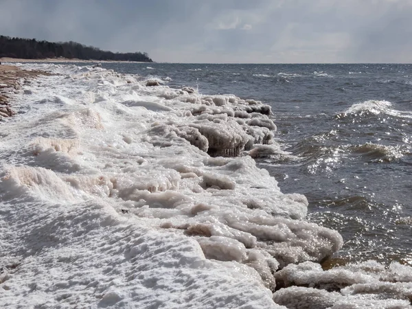 stock image Seascape depicting landscape of Baltic sea and beach with ice and snow formations on the shore in bright sunlight. Frozen ice blocks and sea water in winter